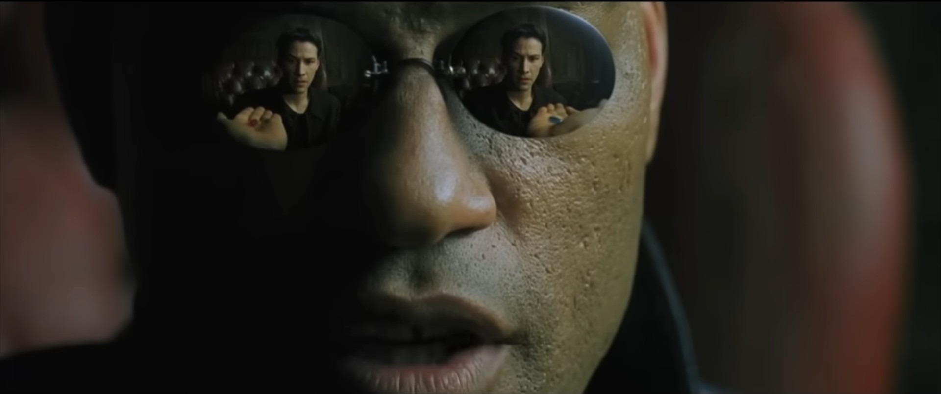 MorpheusがNeoに錠剤の選択を与えるマトリックスの場面――カメラはMorpheusの反射するサングラスに向けられています